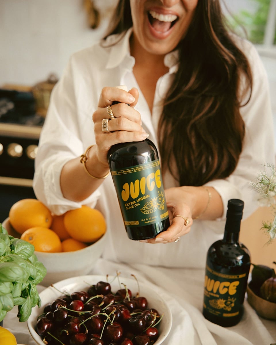 Maria holding a bottle of Juice extra virgin olive oil.