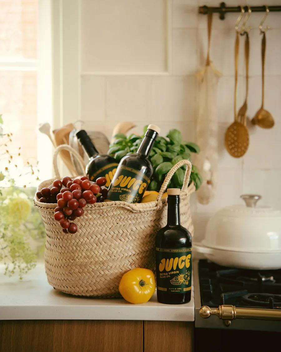 A bottle of Juice extra virgin olive oil in a market tote.