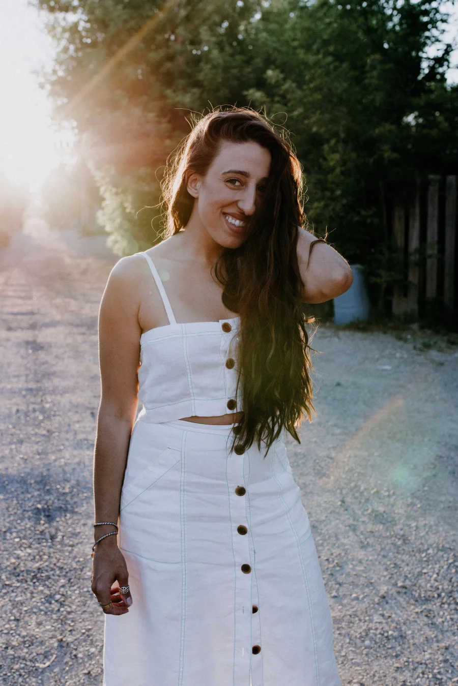 Maria standing outdoors in a white dress.