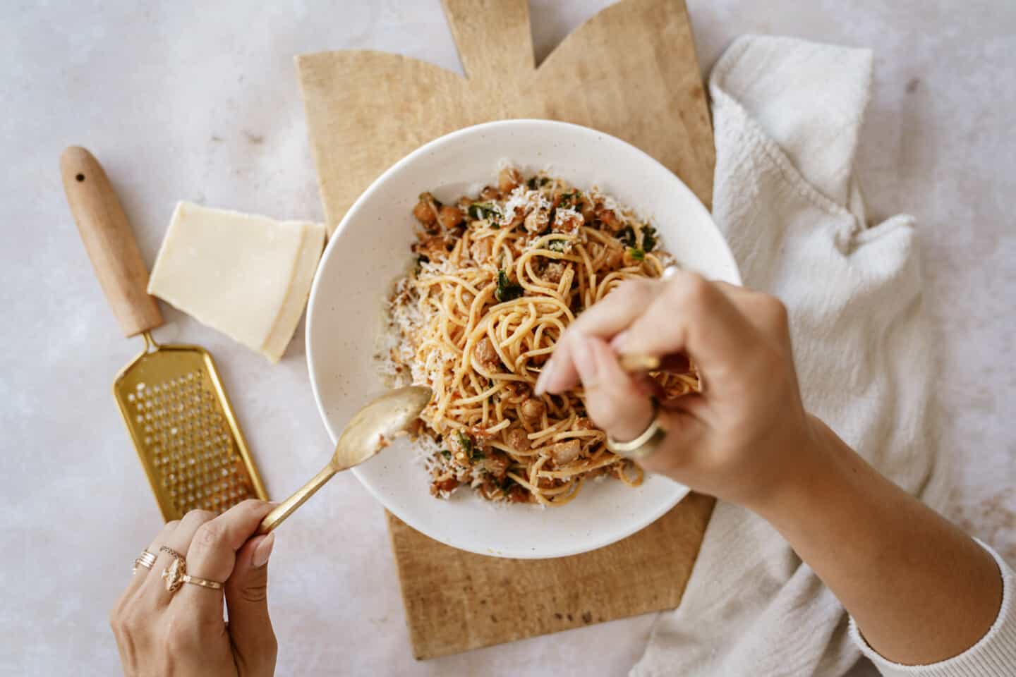 Hands twirling chickpea pasta with fork