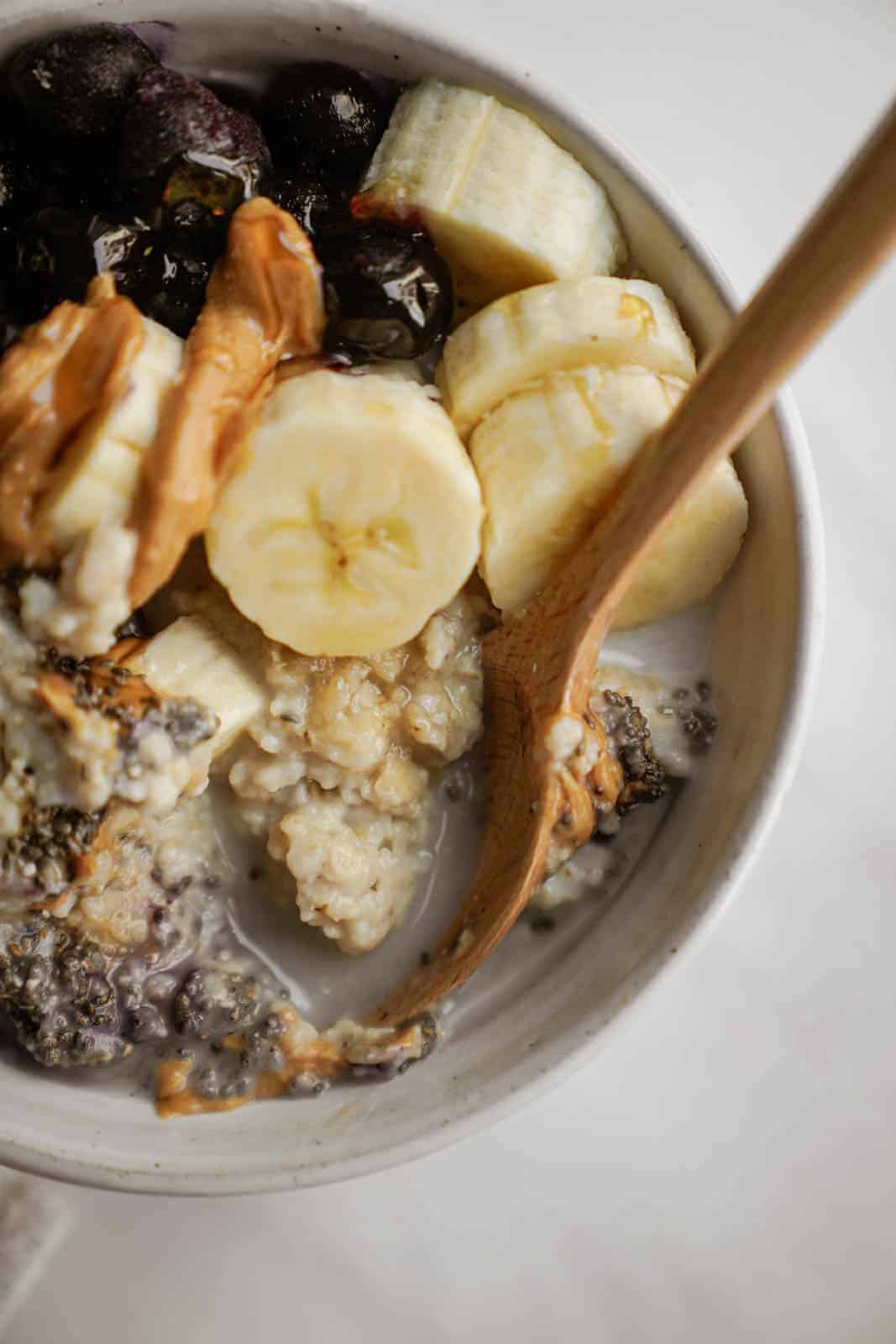 low gi breakfast in a bowl with fruit, peanut butter, and chia seeds on top.