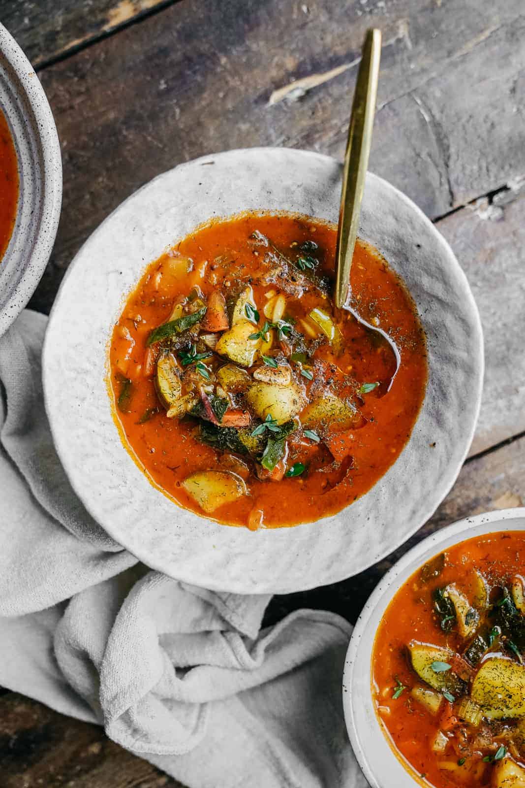 Bowl of Vegetable Orzo Soup on wood countertop.