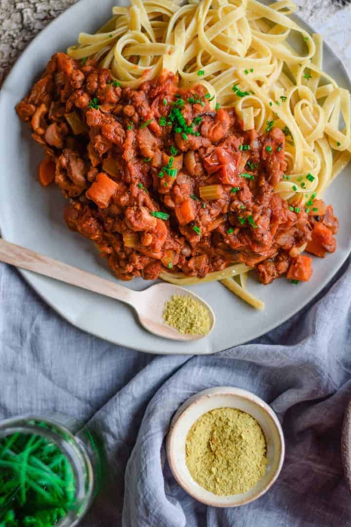 Close-up of plant based pasta on countertop with vegan parm.