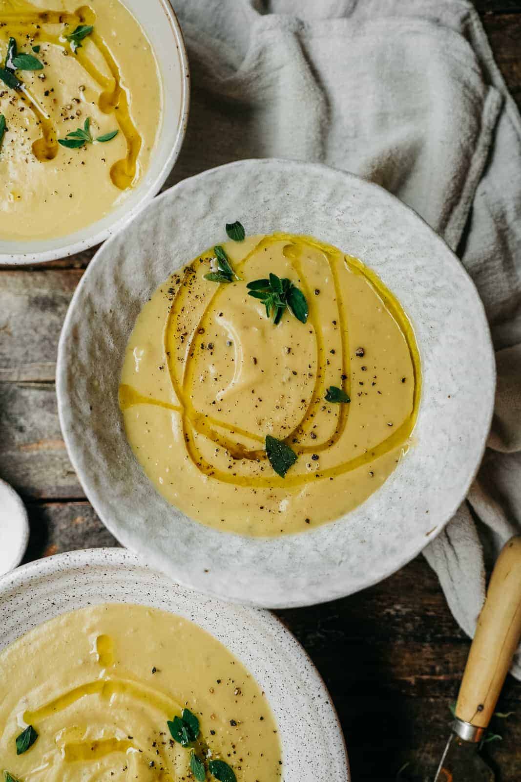 Vegan Potato Soup in white bowls well propped on table.