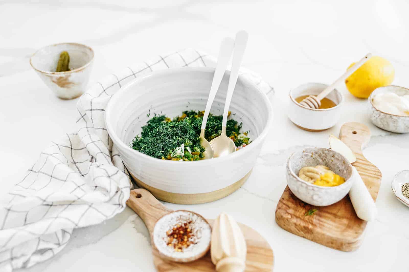 Vegan potato salad on counter surrounded by ingredients.