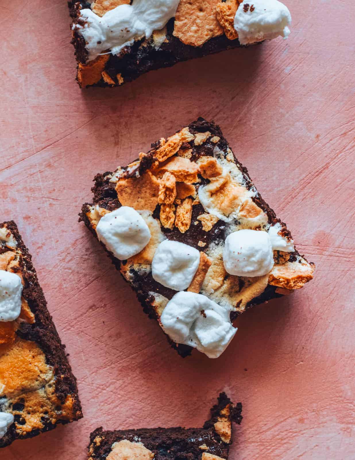 S'mores brownie recipe cut into squares on pink countertop