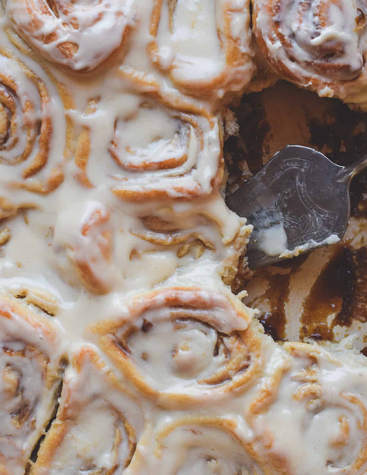 Vegan cinnamon rolls in dish with serving spoon