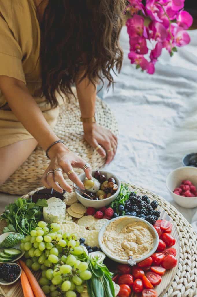 Maria dipping veggies into lentil hummus.