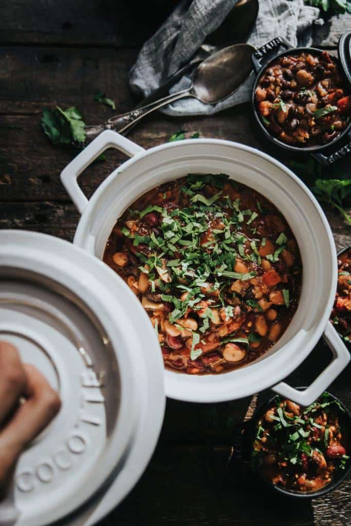 Serving pot of vegan lentil chili topped with fresh herbs. One of my fav vegan lentil recipes.