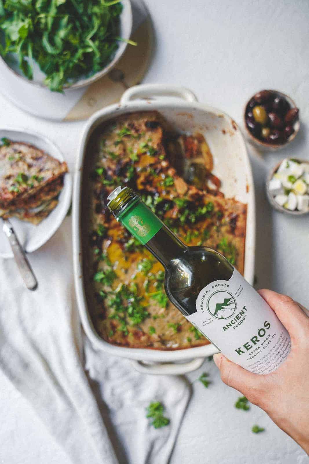 Keros Olive oil being poured onto the cooked vegan moussaka.