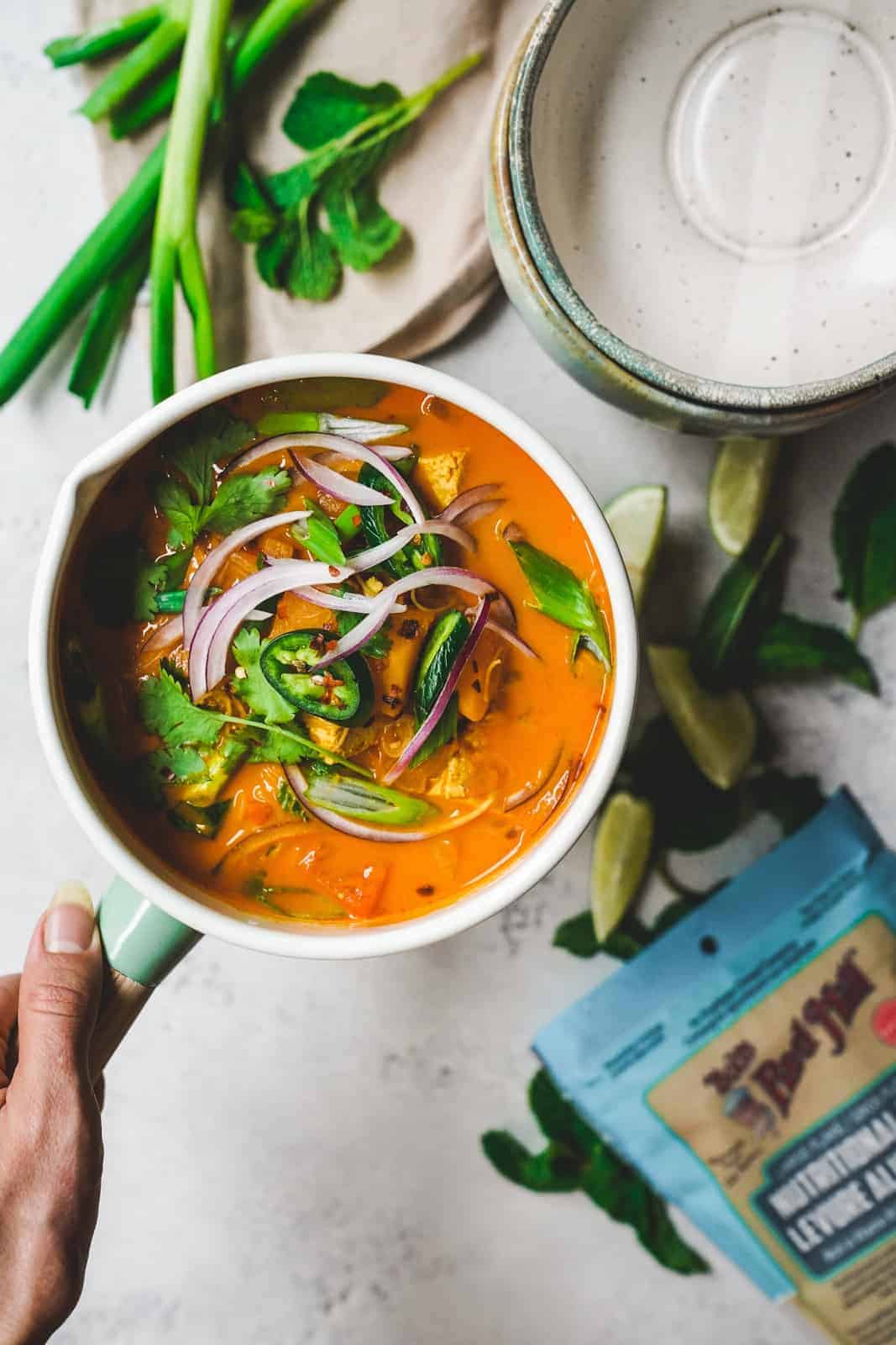 Colorful one pot coconut curry soup in serving dish.