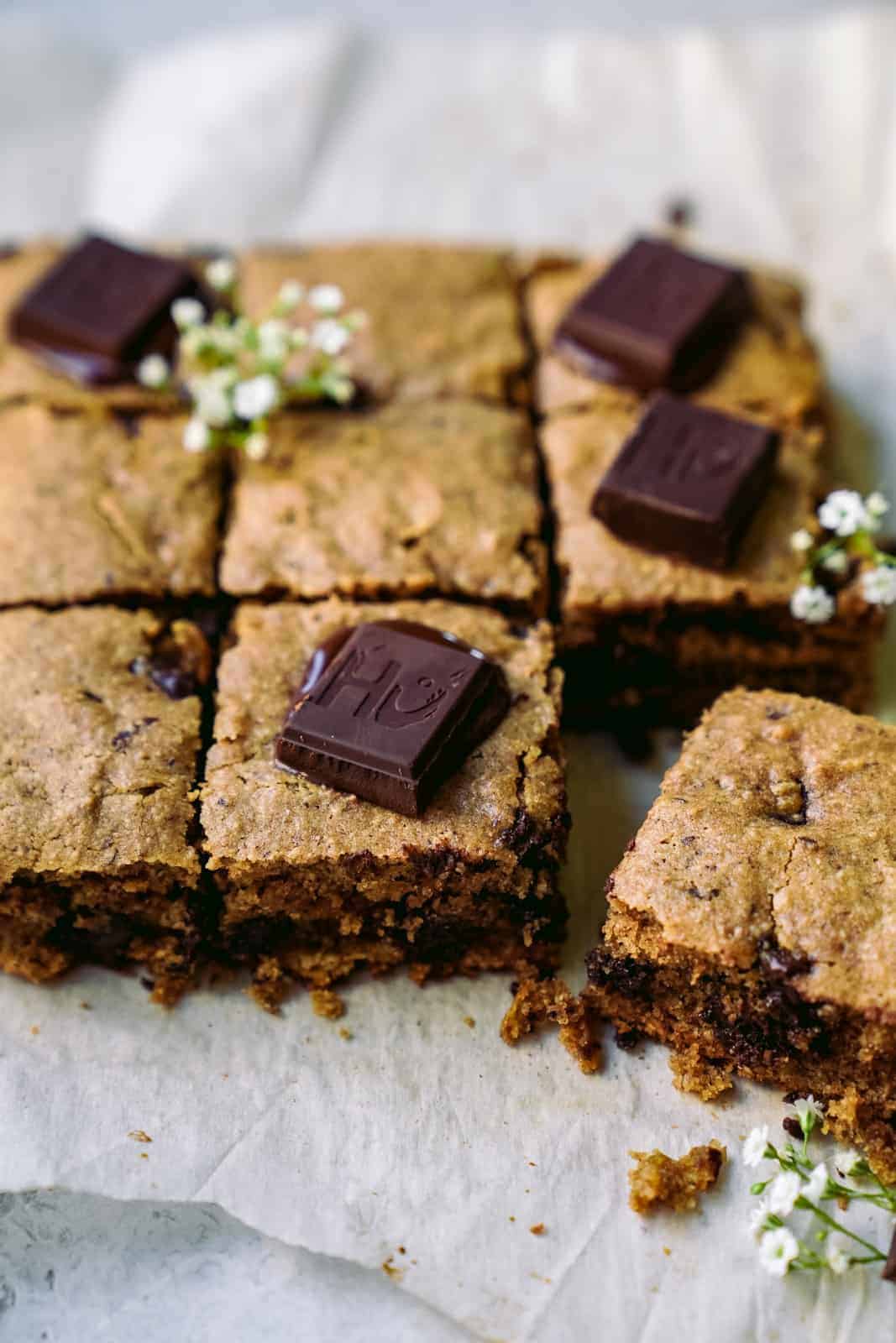 Vegan Blondies cut into pieces with chocolate chunks.