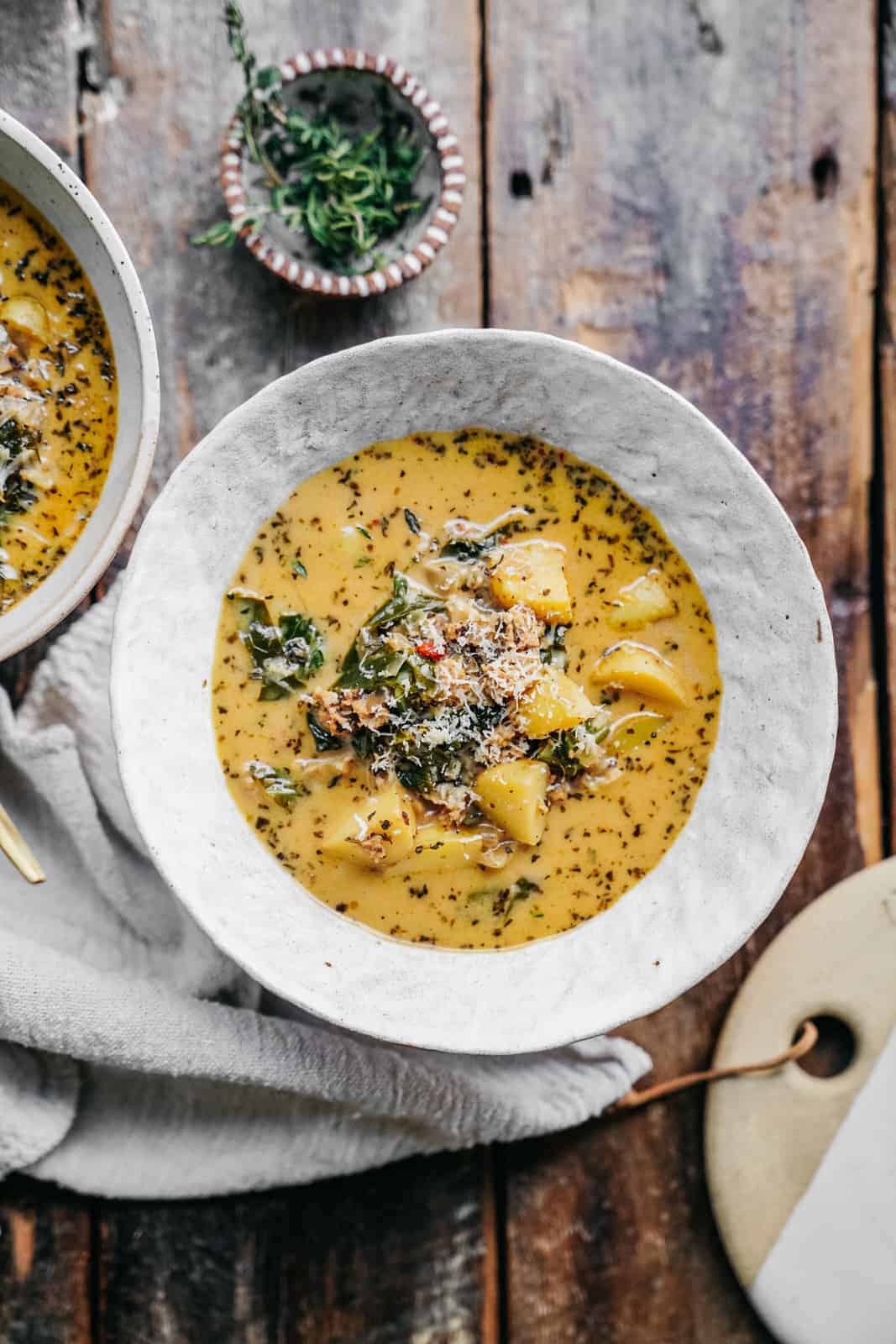 Overhead shot of two bowls of vegan zuppa toscana soup.