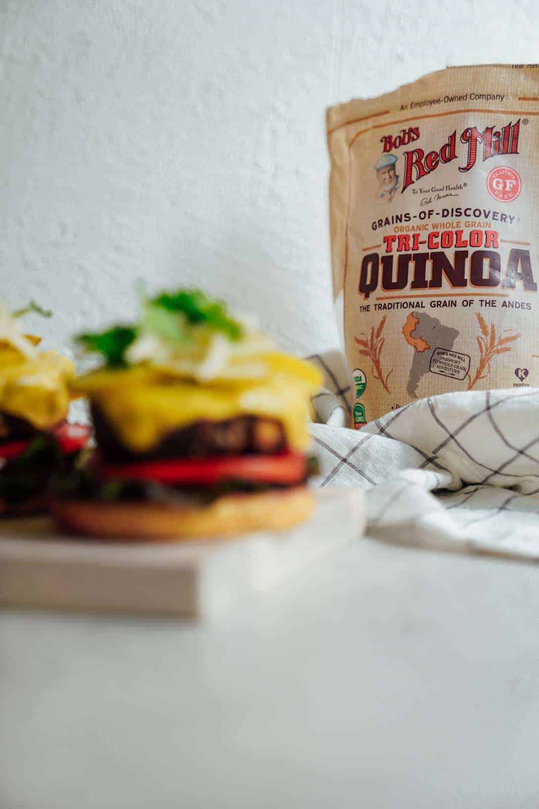 Burger in the forefront with quinoa in the back