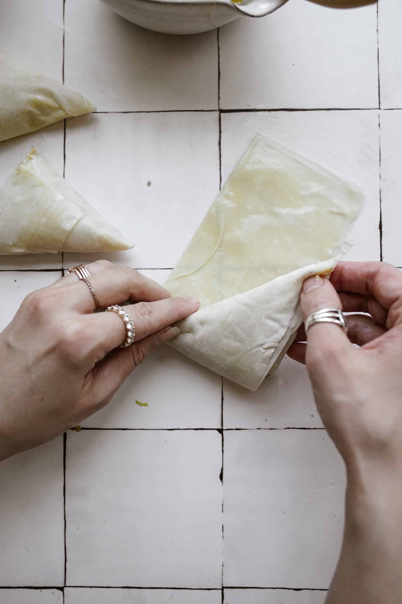 Rolling the spinach pies into bite-size triangles