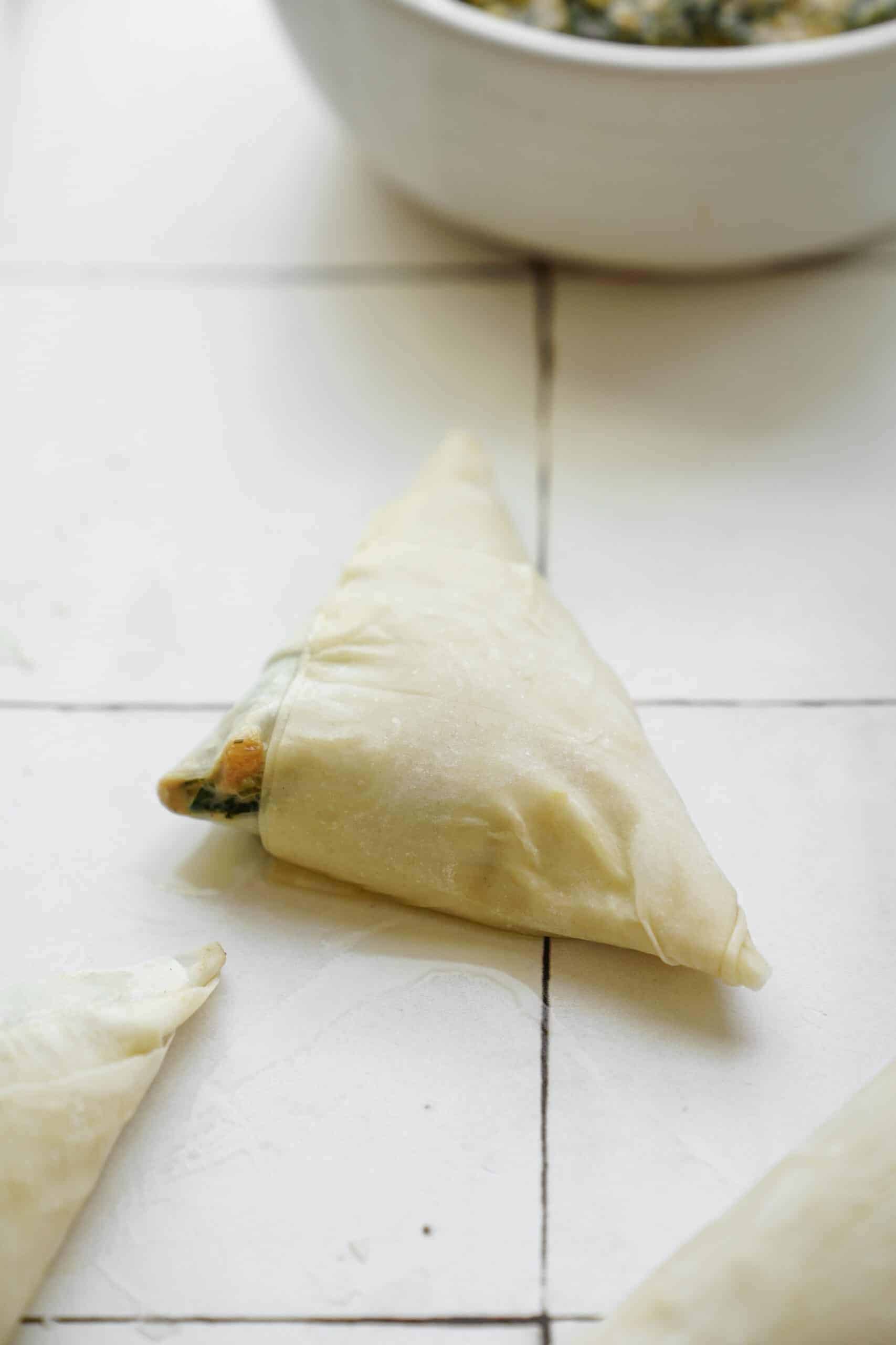Spinach pies on counter top ready to be baked