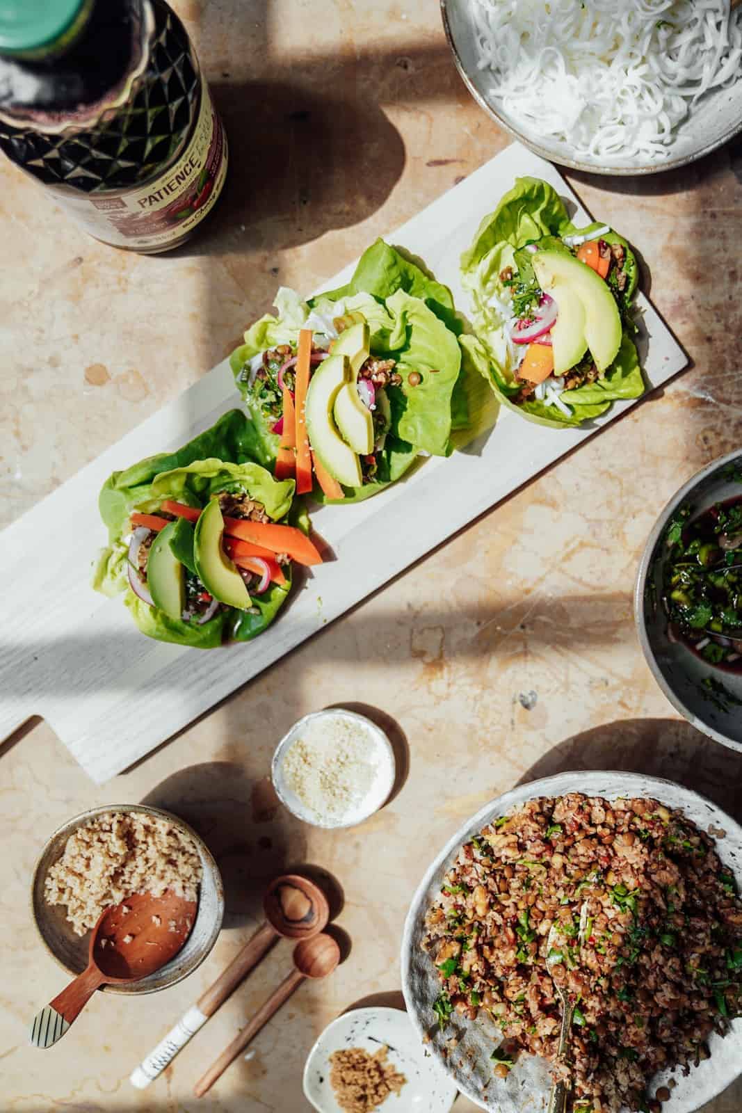 Vegan Lettuce Wraps on a serving platter on a table with Patience Fruit & Co. juice.