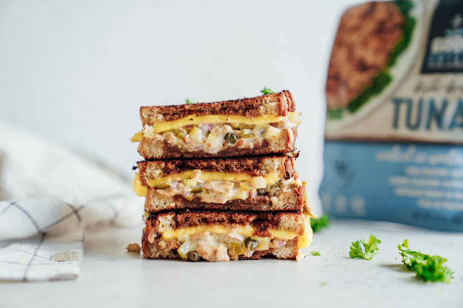 A stack of cheesy vegan tuna melts on countertop.