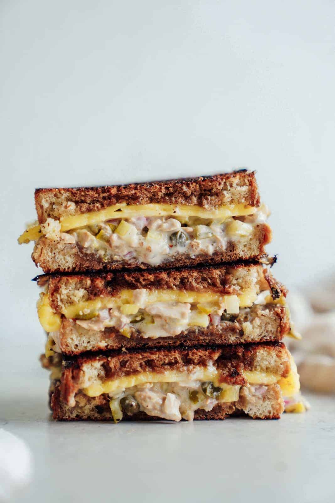 A stack of cheesy vegan tuna melts on countertop.