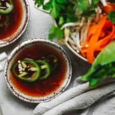 Vegan fish sauce in little bowls with fresh peppers on top