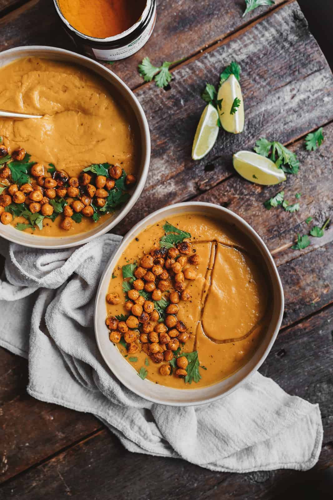 Overhead shot of Vegan Vegetable Soup on table with garnishes on the side.