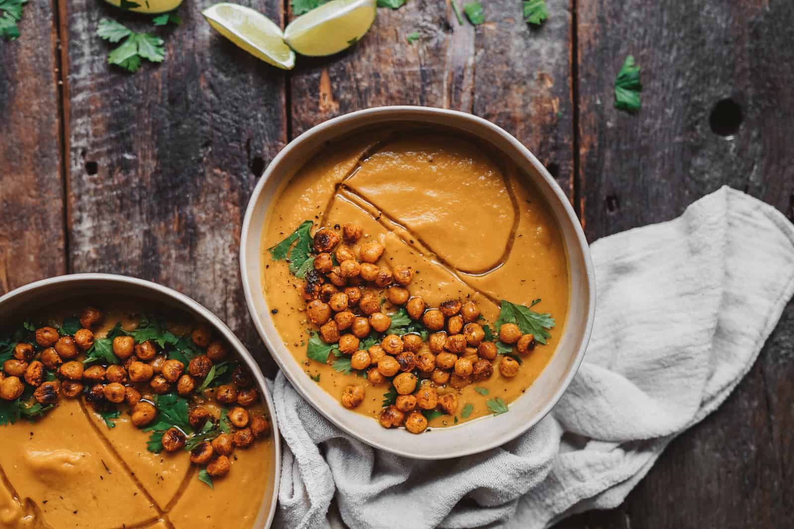 Overhead shot of Vegan Vegetable Soup on table with garnishes on the side.