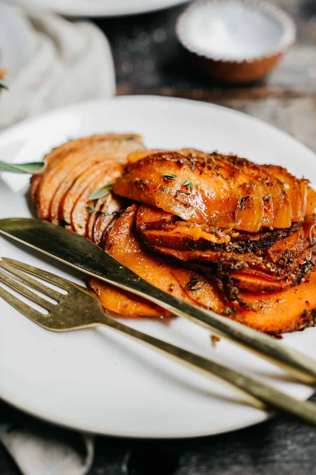 vegan sweet potato casserole on a white dish with fork and knife