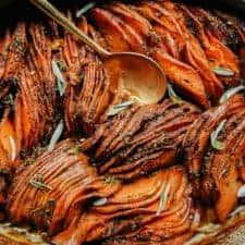 Close-up of vegan sweet potato casserole with serving spoon in casserole dish.