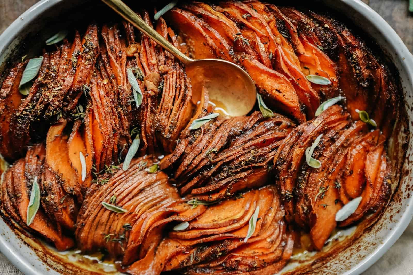 Close-up of vegan sweet potato casserole with serving spoon in casserole dish.