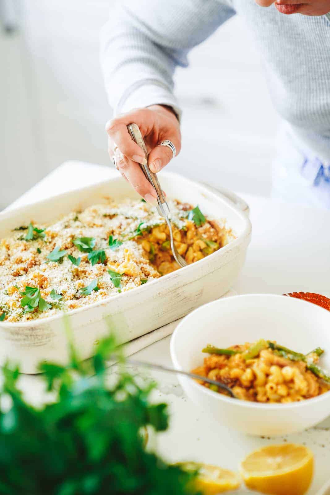 Maria digging into the vegan casserole in a serving dish.