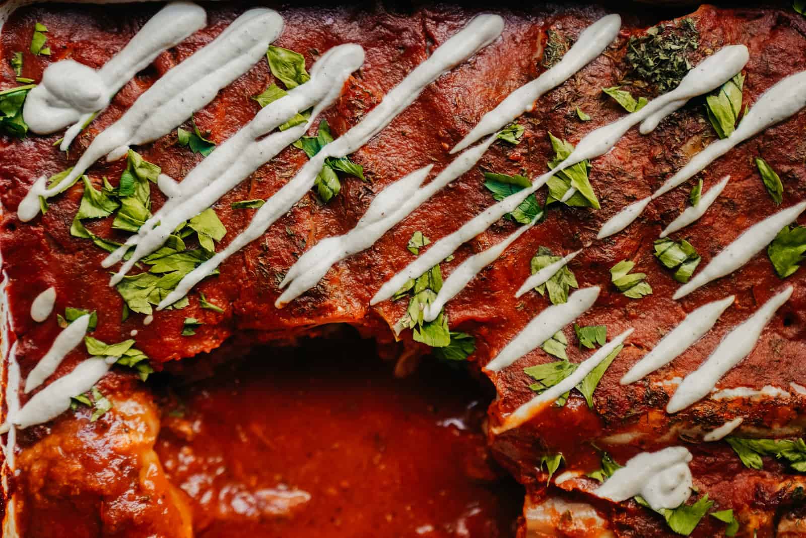 Getting up close with the Best Vegan Cabbage Rolls. Vibrant red from the tomato sauce with a piece missing.