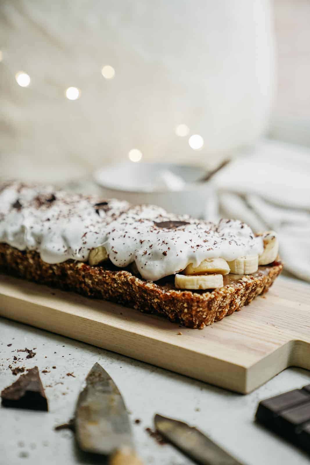 Side angle of vegan banoffee pie with whipped cream on top.