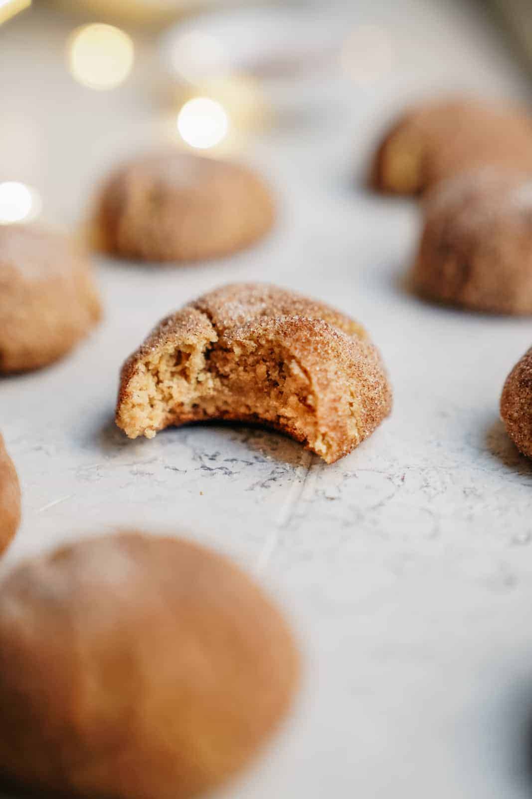 One of the best christmas cookie recipes - sugar cookies laying on a baking sheet with one bite out of it