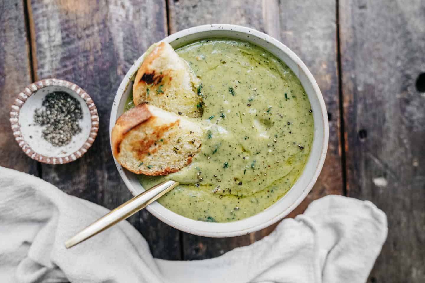 Creamy broccoli soup with pieces of bread served with it