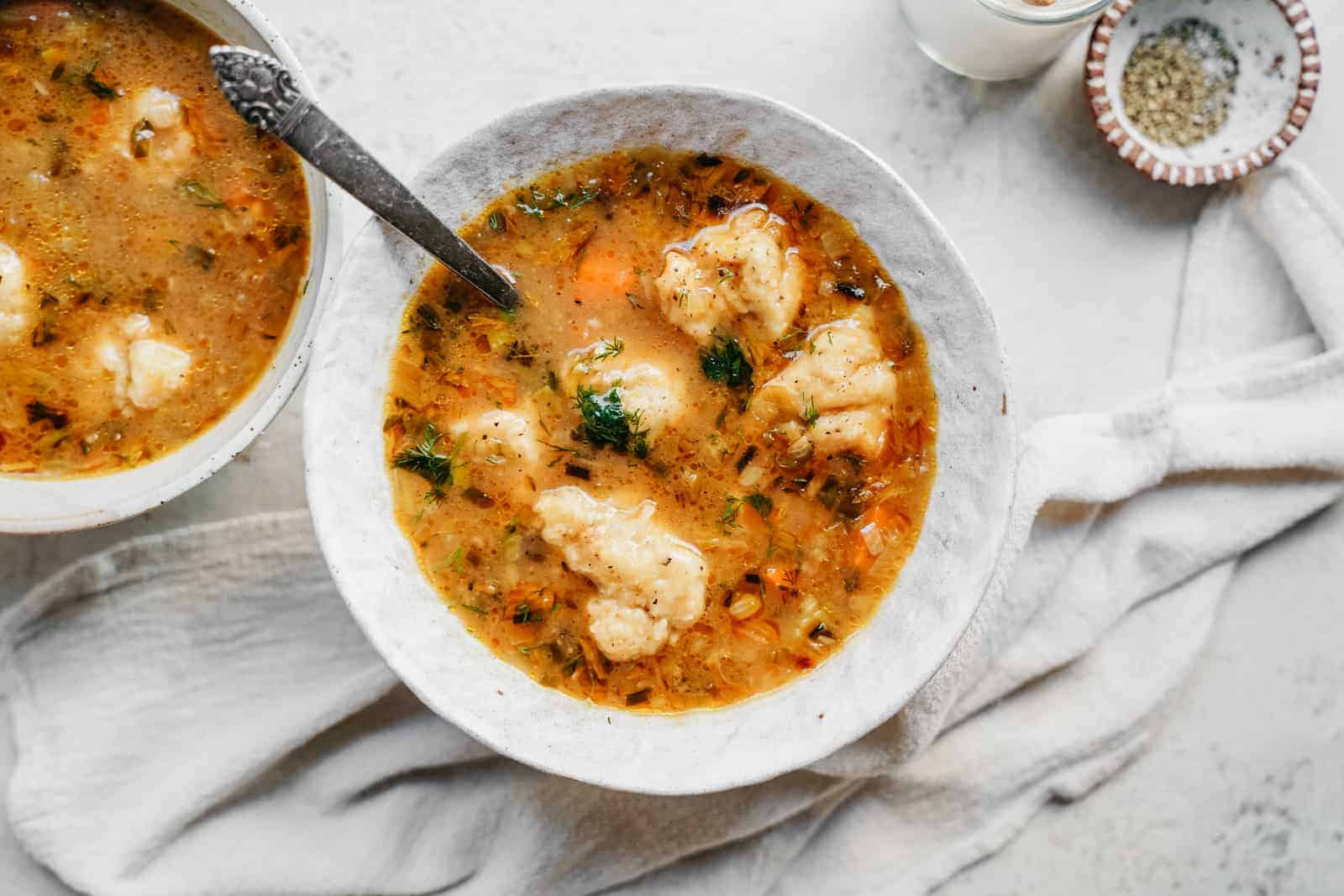 vegan dumplings & vegetable soup in bowls on countertop