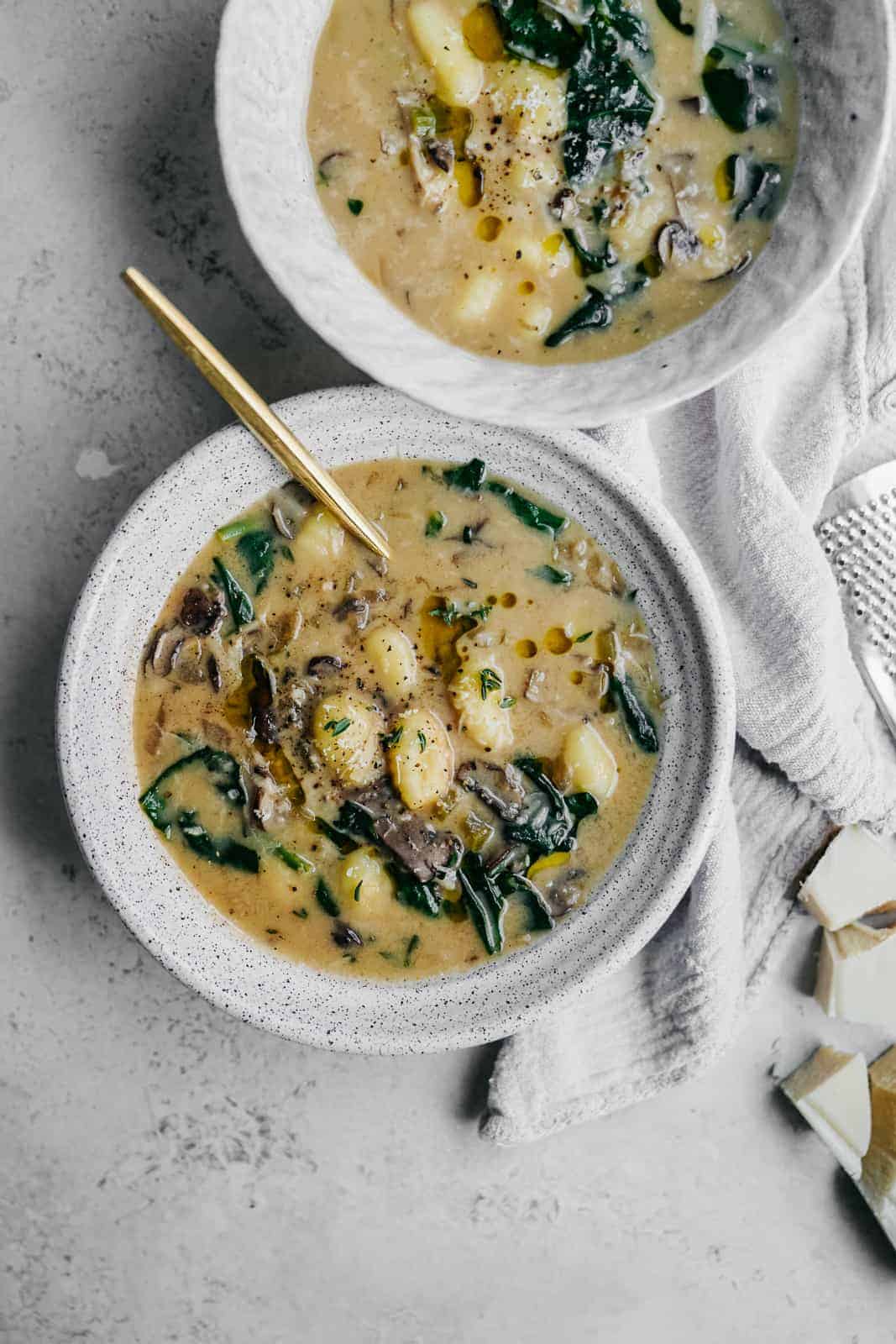 Creamy soup in multiple white bowls on countertop. A delicious vegan spin to a classic Olive Garden favourite.