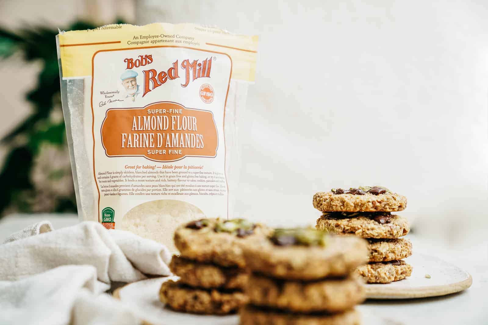 Breakfast cookies stacked on plates with bag of flour in back