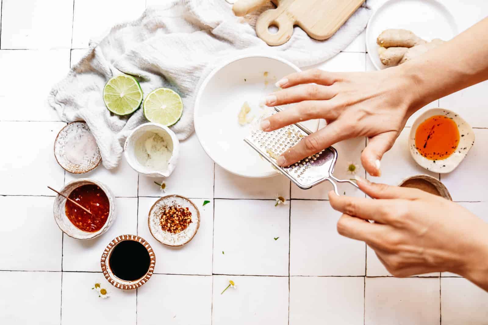 Person showing you how to make peanut sauce in a bowl on a white countertop