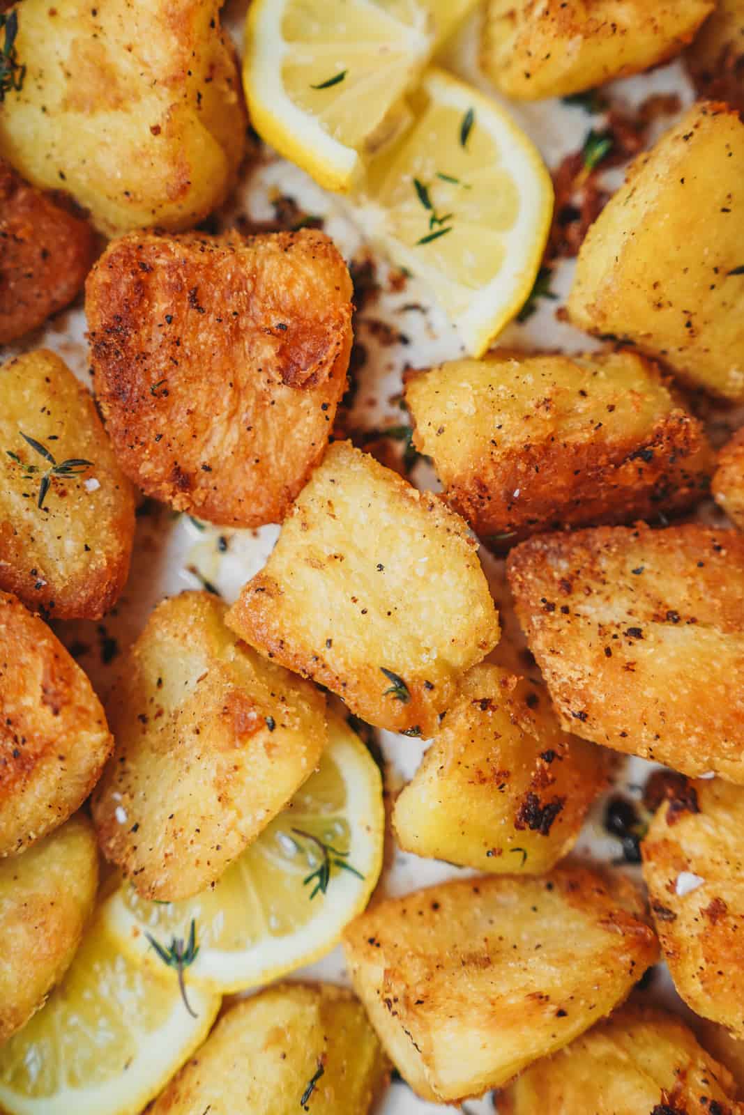 Close-up of crispy potatoes with lemon slices