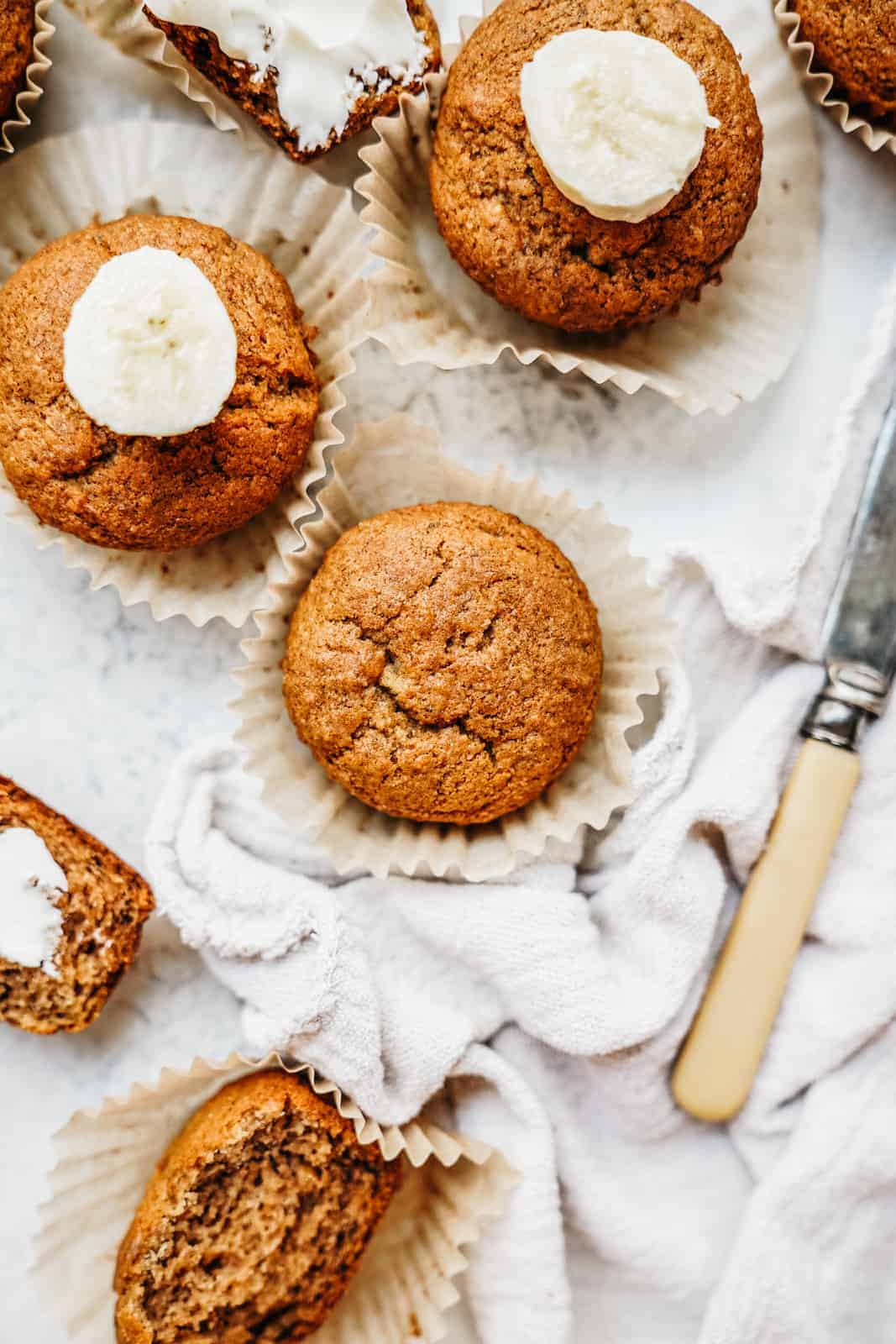 banana bread muffins on a counter next to a knife