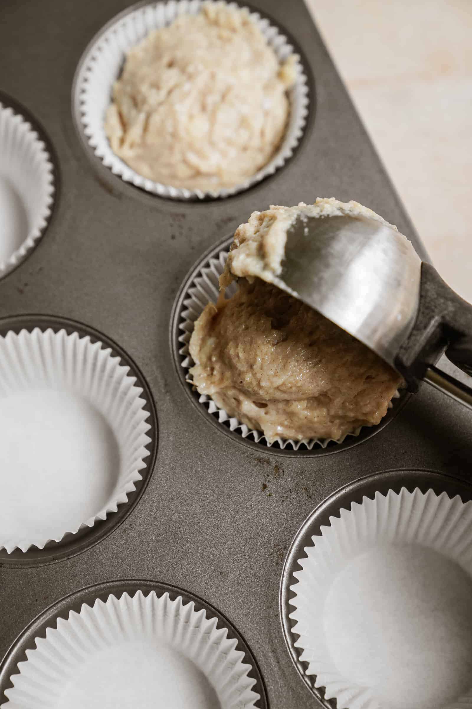 Ice cream scoop putting batter into muffin tin