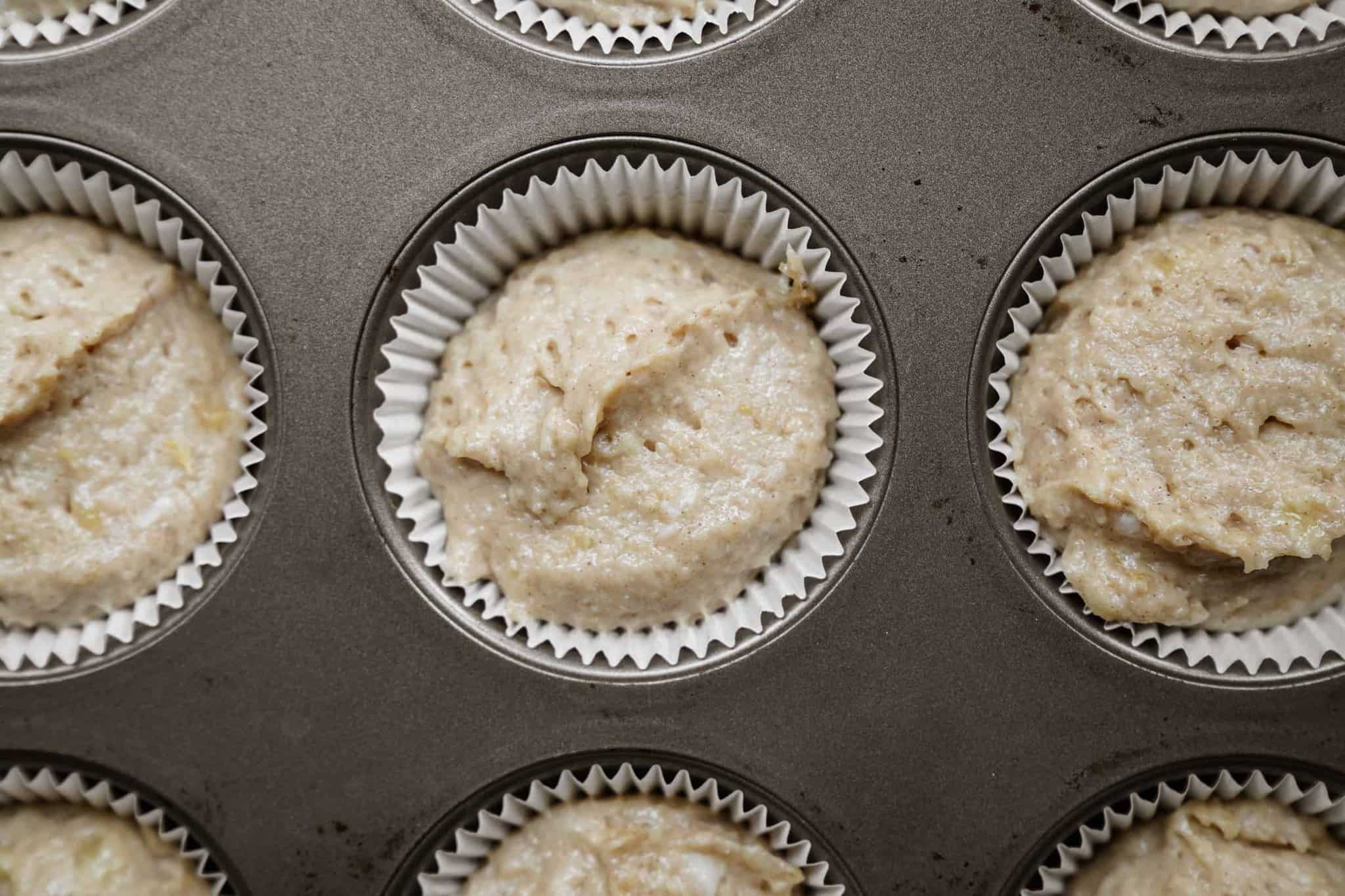 Muffin tin of vegan banana muffin batter pre-cooked