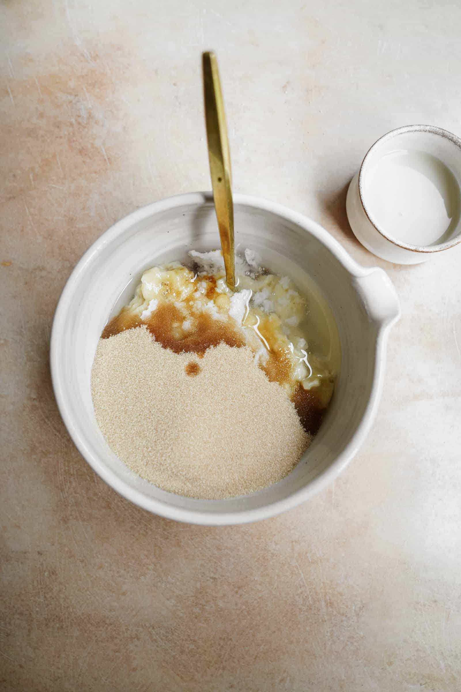 Bananas mixed into dry ingredients for vegan banana muffins