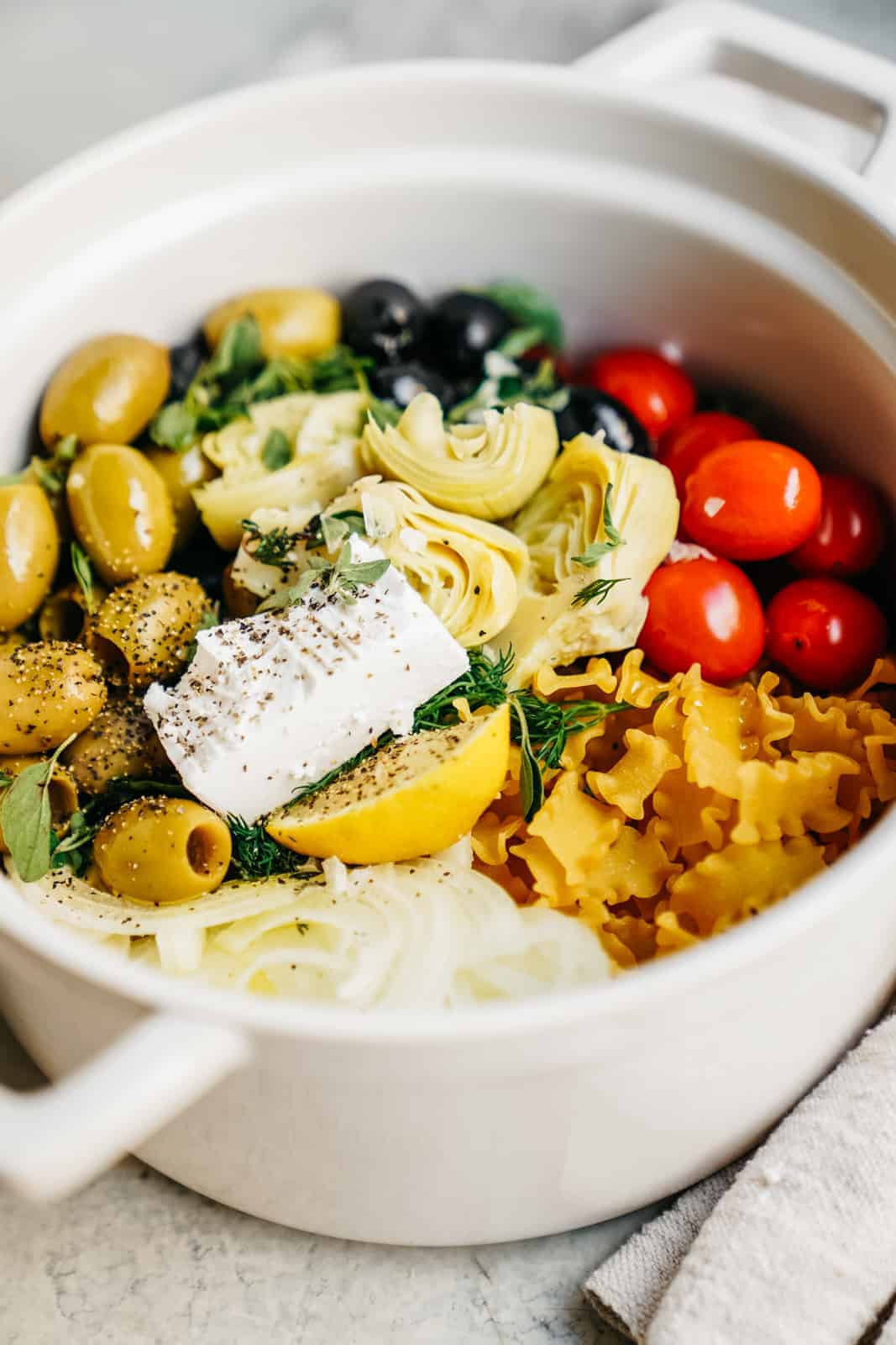 Close-up of a big pot with all the ingredients for a one pot greek pasta. One of my favorite, easy, vegan meals.