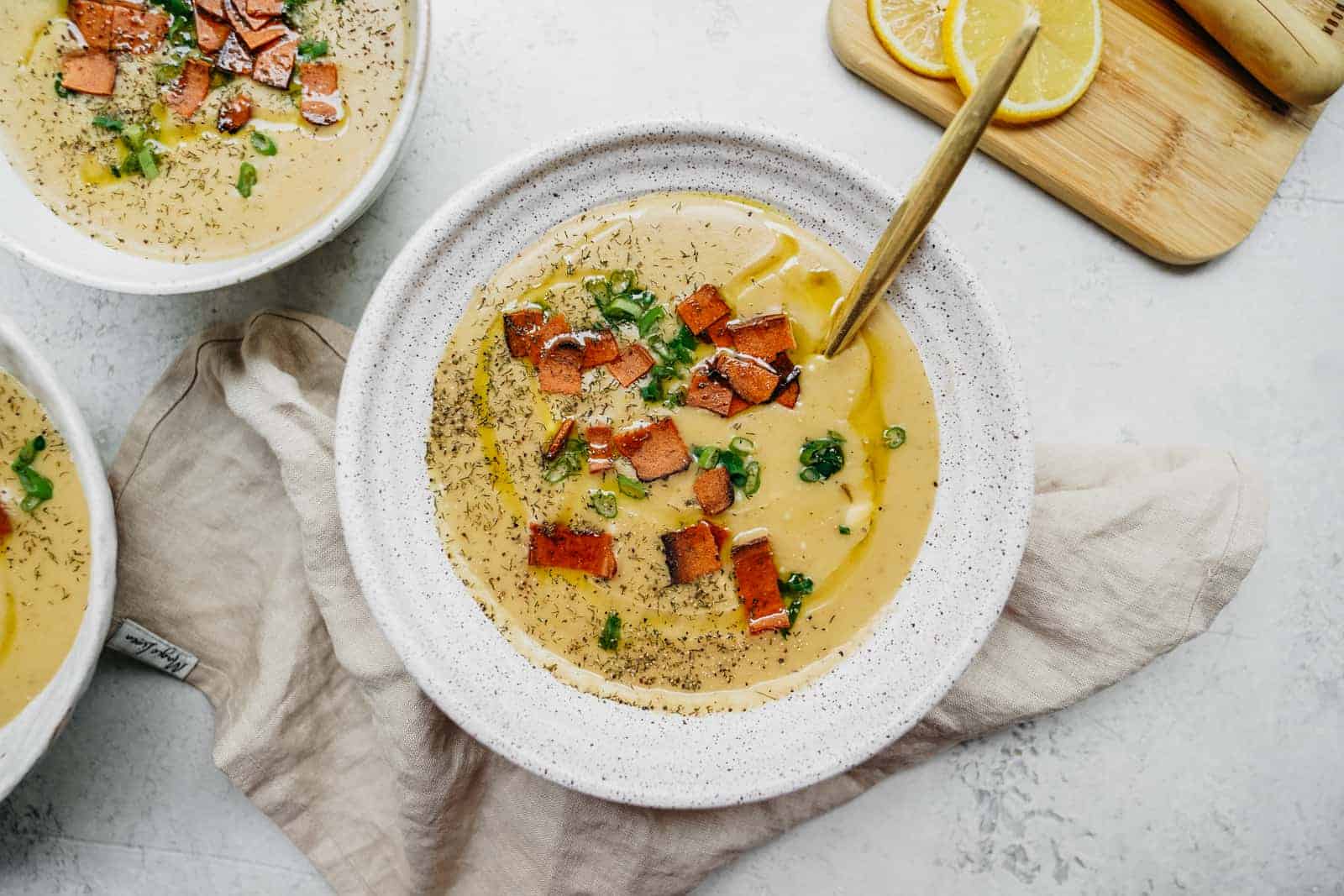 Big white bowl of soup ready to be eaten on countertop.