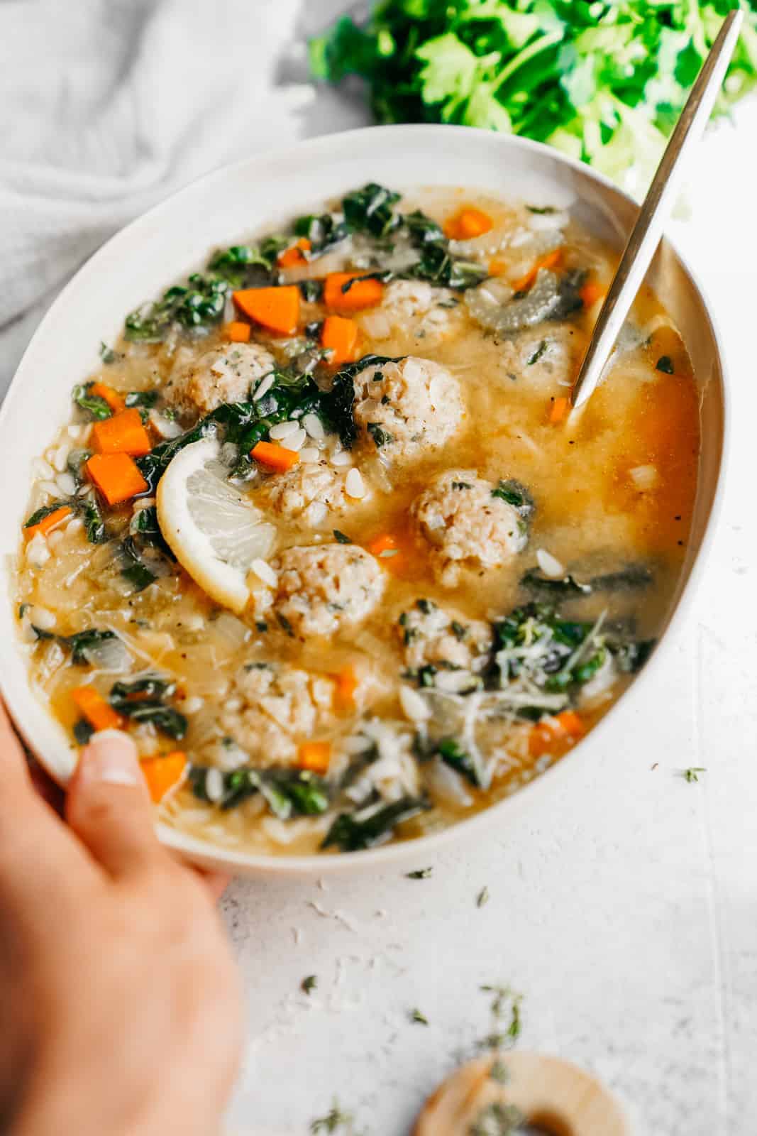 Close-up of Italian Wedding Soup in white serving bowl.
