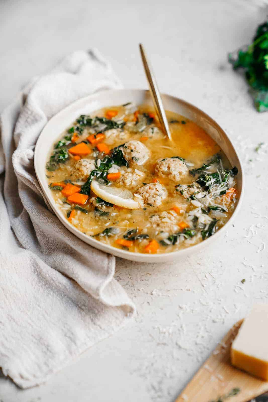 Italian Wedding Soup in a serving dish with a spoon. A delicious soup recipe!