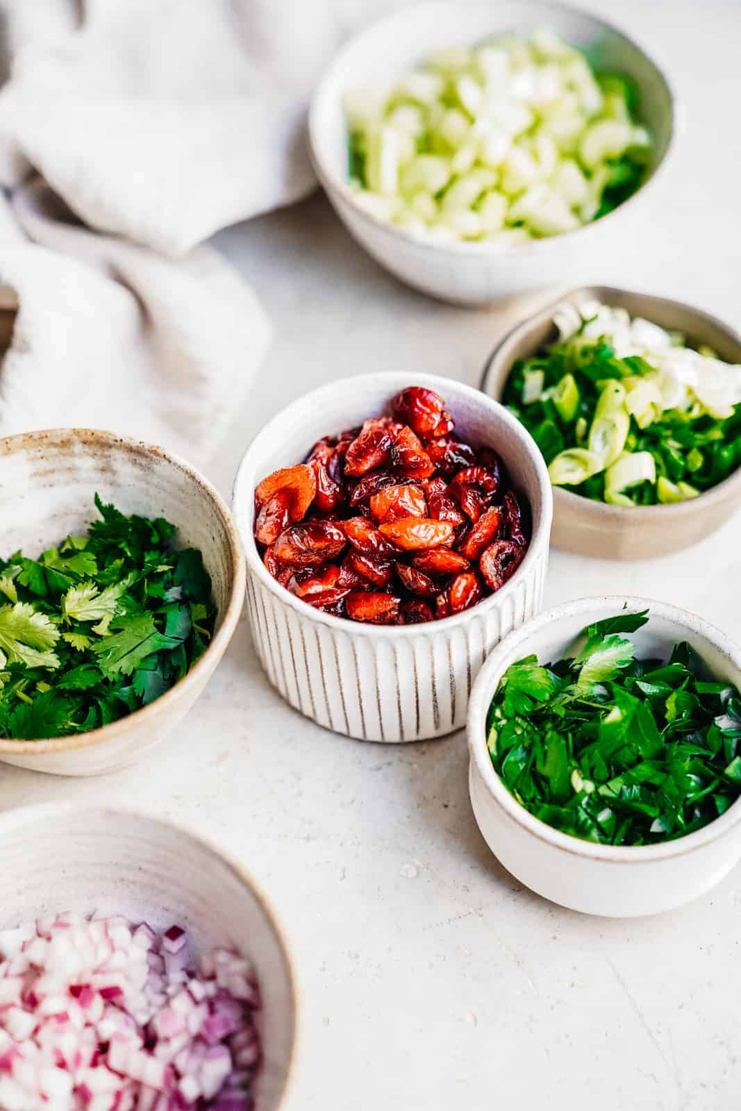 Fresh herbs scattered in serving bowls around the table.