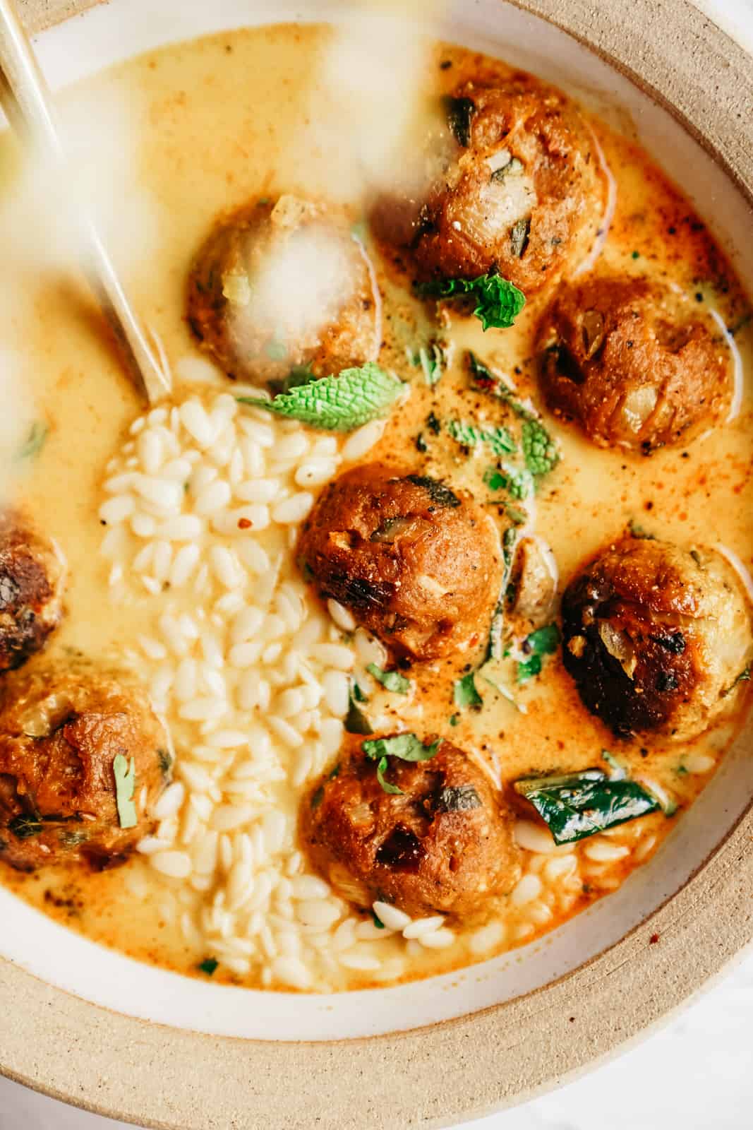 Close-up of meatballs in creamy bowl of vegan soup.