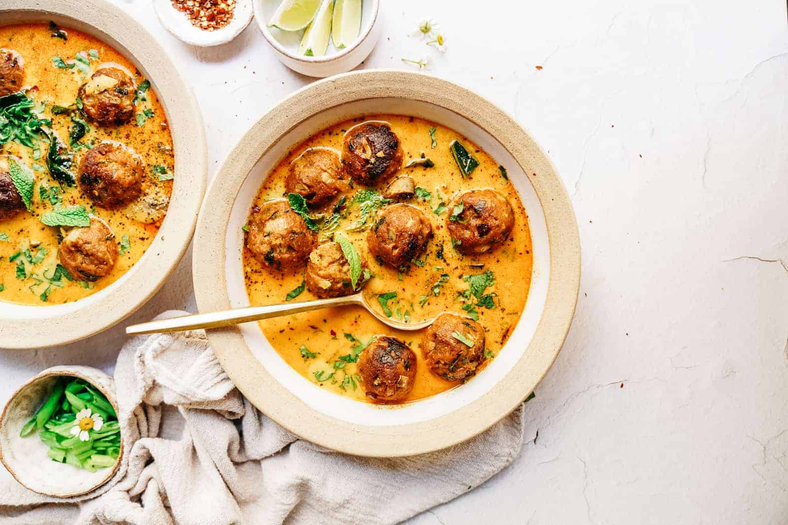 Curry Meatball Soup, a creative soup idea in two big serving bowls with a spoon